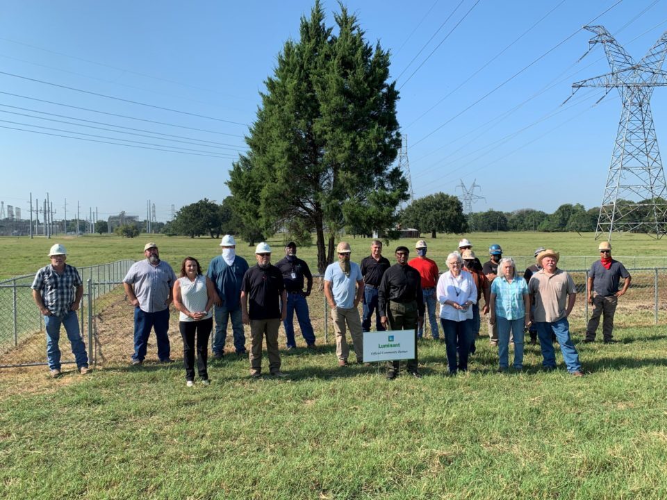 luminant employees pose in front of cemetary